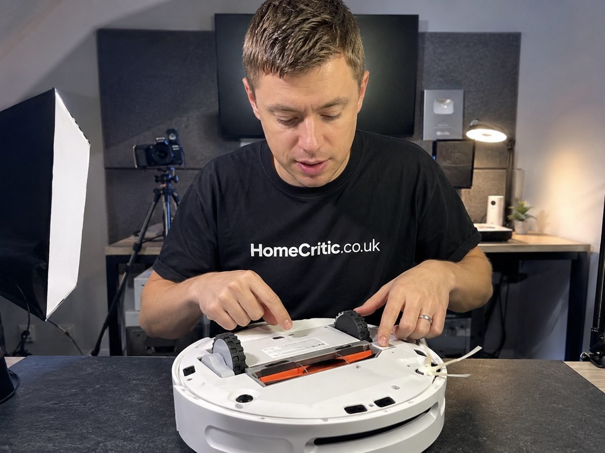 HomeCritic tester inspecting the underside of a robot vacuum